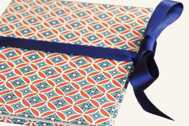 Small photo book with geometrically arranged rhombuses, blue, red, white, blue bow